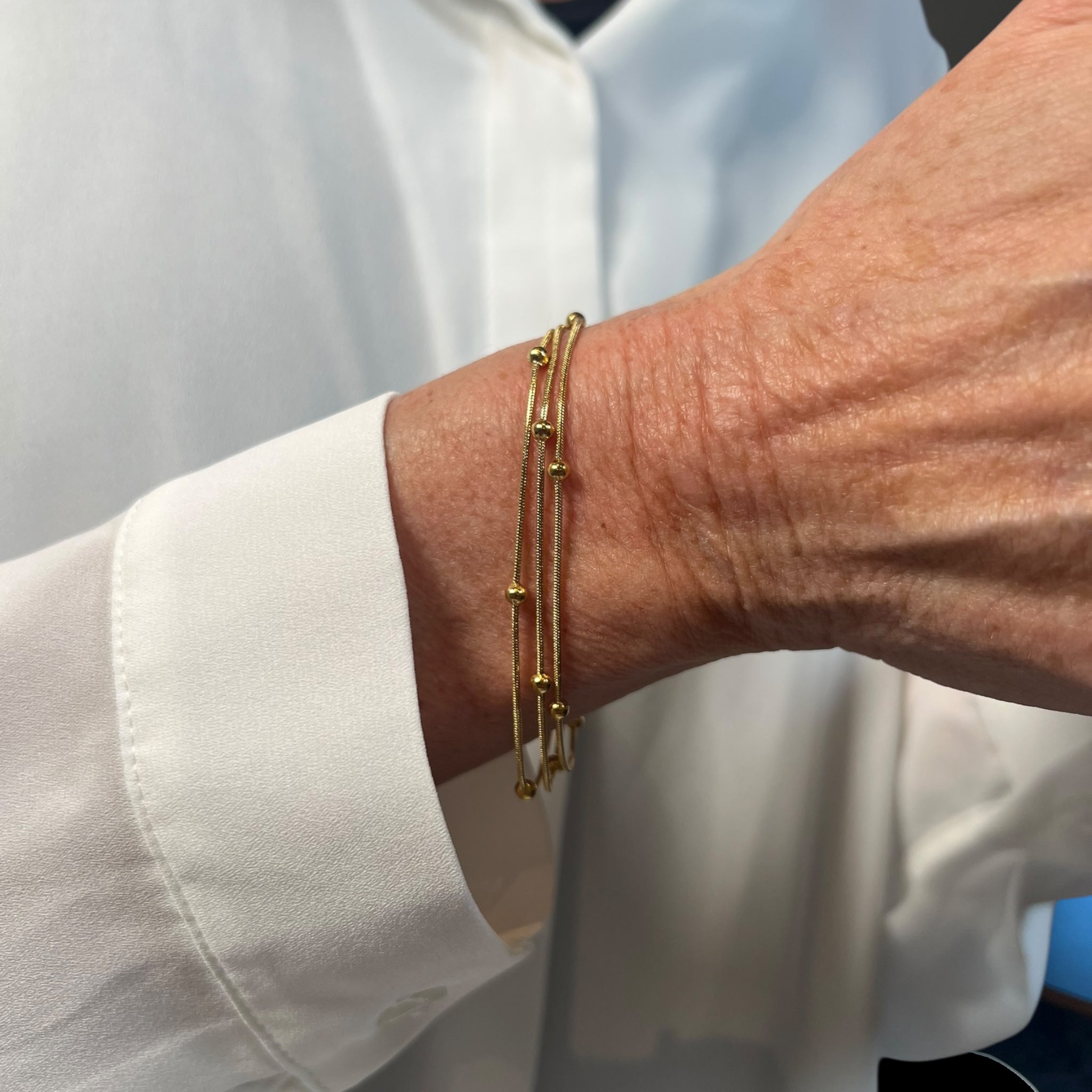 Flerlaget armbånd med små gulddetaljer